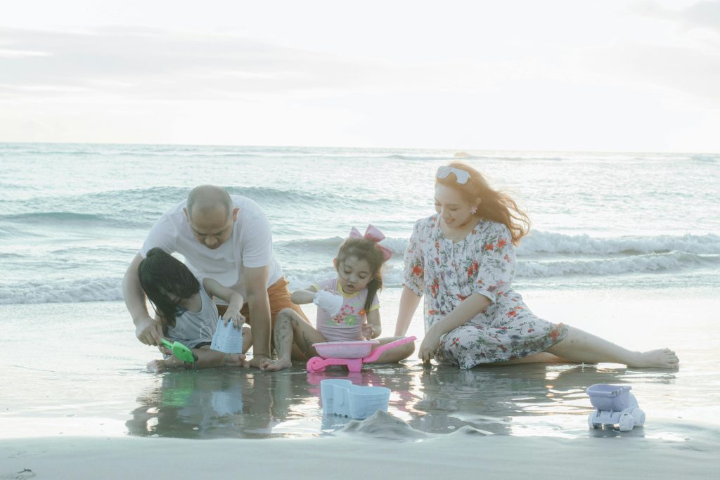 A family playing together on the beach during sunset, creating joyful memories.