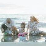A family playing together on the beach during sunset, creating joyful memories.