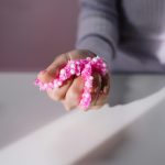 A hand holds vibrant pink foam slime, showcasing texture in soft lighting.